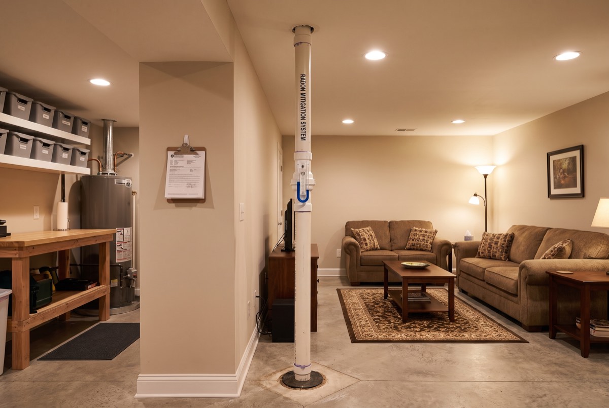 Labeled radon mitigation system pipe with manometer in a finished Bowling Green, KY basement