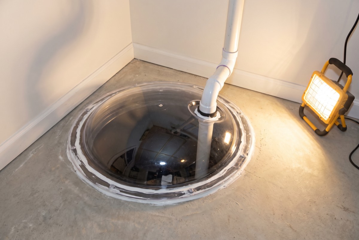 Sealed sump pit with airtight dome and radon suction pipe in a Kentucky basement